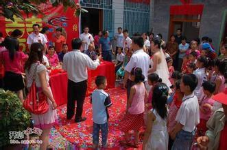 礼花筒一顿朝向新人乱喷,鞭炮响起,喜糖撒给看热闹的人,然后拜天地