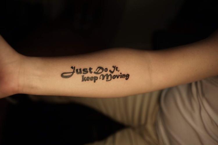 阳光的王先生手臂上的可爱字母纹身图案