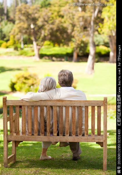 老夫妇坐在公园里的长椅上