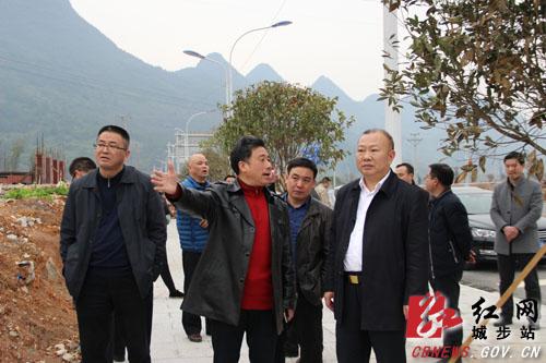 湖南省城步县委书记罗建南在武靖高速连接线项目现场听取情况介绍