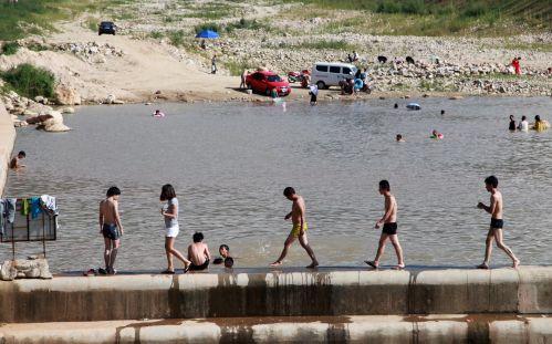 天热难耐 多名男女水坝游野泳