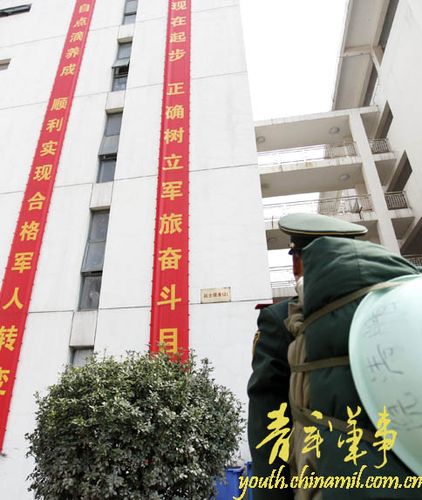 图七,新兵倪清鹏看着部队励志横幅,憧憬未来.