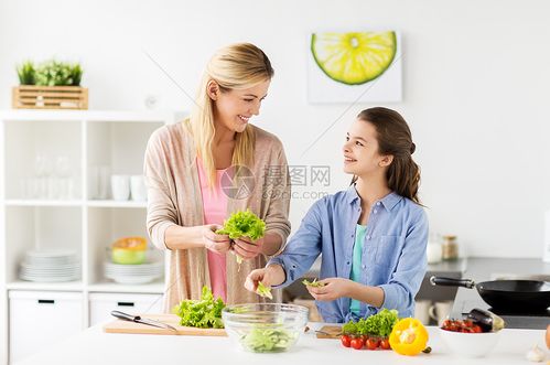 母亲和女儿在厨房烹饪沙拉