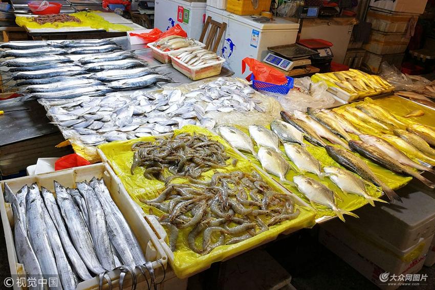 2018年5月14日,山东青岛一海鲜市场,摊位上摆放丰富的新鲜海鲜.