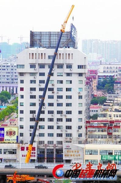 7月5日,市城管执法局在拆除宁夏路裕丰大厦17层楼顶上的广告时,请来了