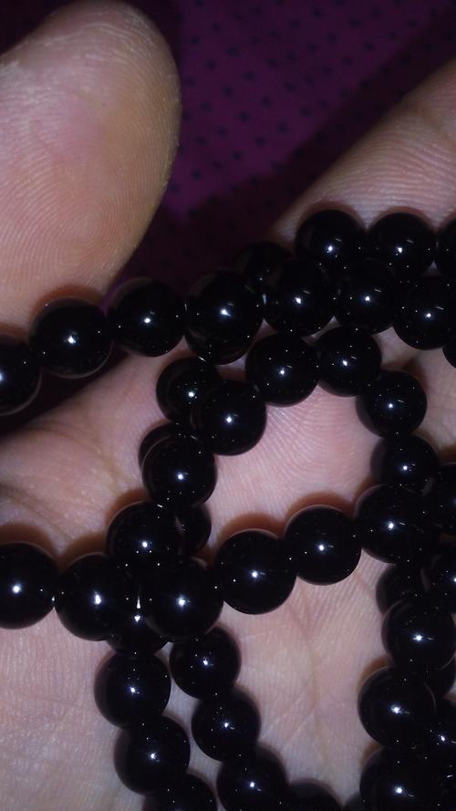 这是什么珠子,黑色的不透明 以前买黄金送的 用手电筒