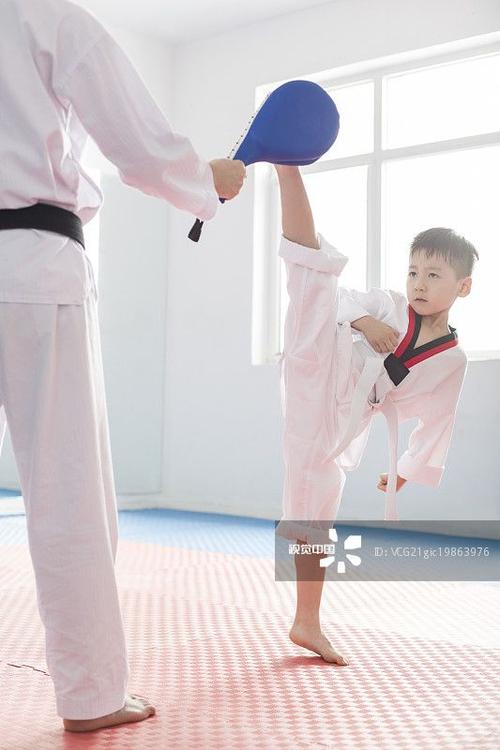 年轻教练教小男孩跆拳道_创意图片
