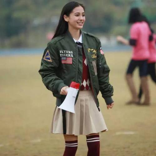 angelababy以飞行员夹克搭配菱格纹针织衫,百褶短裙和长筒袜的造型