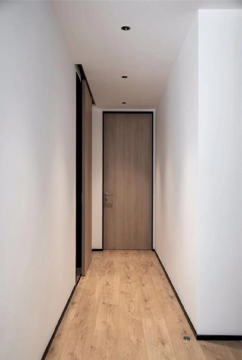 黑色窄边框门洞与踢脚线融为一体,这些现代简约元素用在走廊里,干净