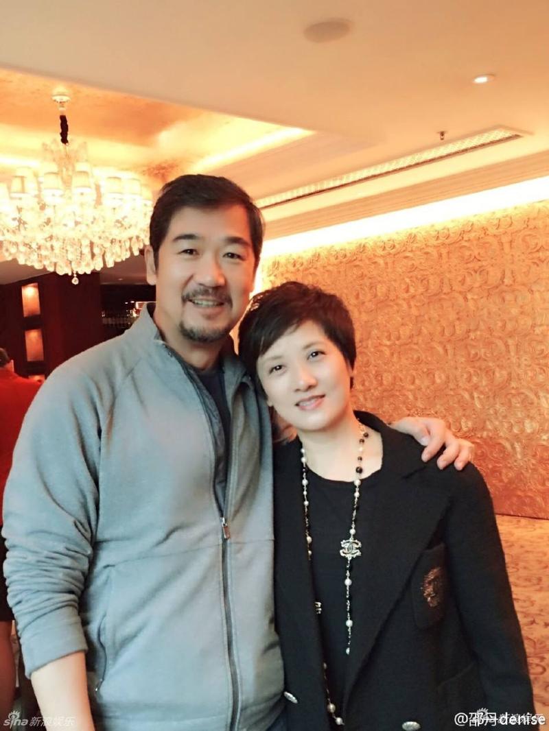 张国立一身休闲装在后推行李车实力宠妻,老婆邓婕走在前狂玩手机.