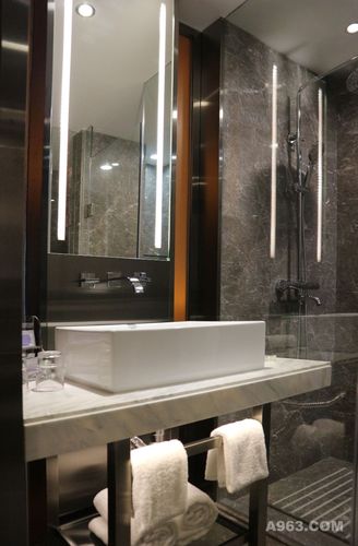 卫生间墙地面采用雪域灰的大理石,加深了整体的空间氛围,透过茶色夹胶