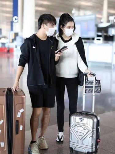 奚梦瑶牵手老公走机场,白色卫衣穿搭高级又时髦,不愧