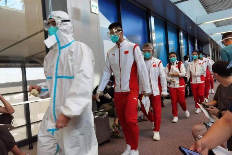 中国乒乓球队代表团刘诗雯,刘国梁身着中国队队服,佩戴口罩和护目镜