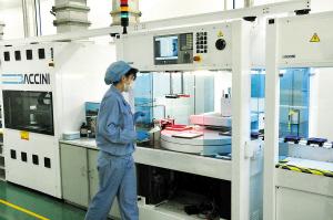 尚德太阳能公司光伏电池生产车间,工人们正在监控自动生产线的运行.