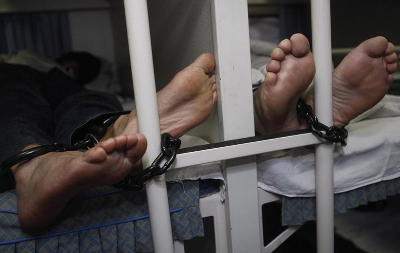 嫌疑人睡觉时为防止意外,侦察员将脚镣拷在卧铺的爬梯上.