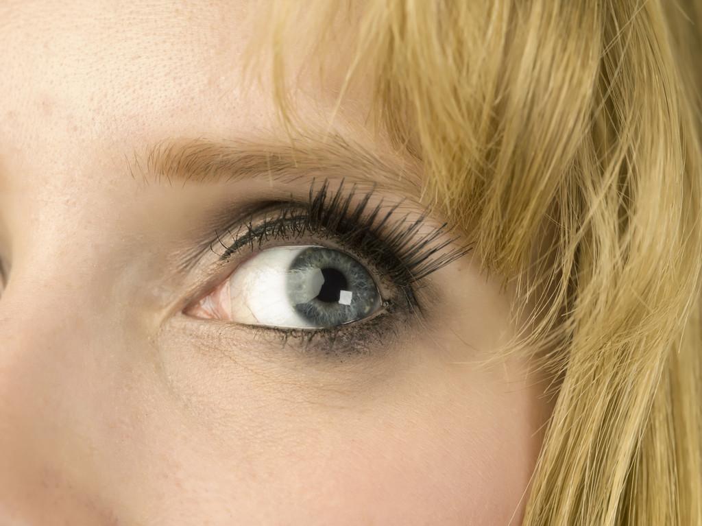 灰色眼睛,一个金发女人的灰色眼睛仰望的特写镜头