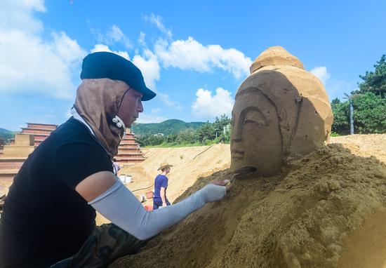 8月16日,浙江舟山朱家尖南沙景区沙雕区,沙雕手在进行沙雕创作.
