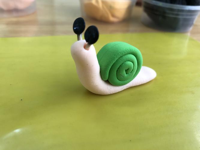 把黑色的彩泥插入蜗牛头顶的牙签内.看～漂亮的蜗牛做好了!