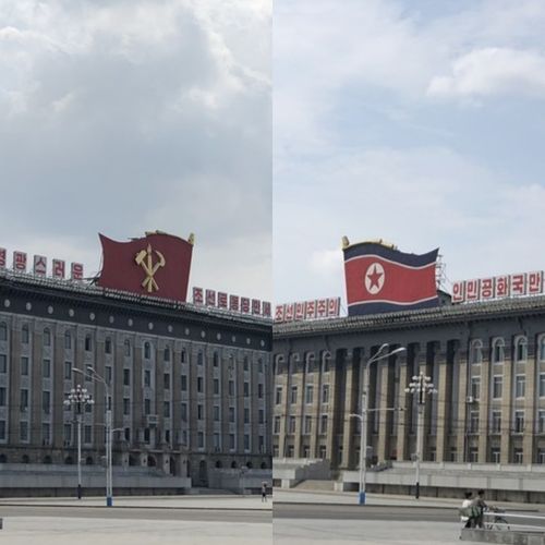 广场两侧的大厦上分别立着朝鲜国旗与朝鲜劳动党党旗.