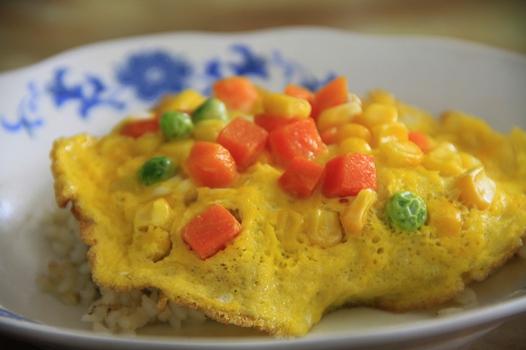 米饭和火腿炒好 2. 摊鸡蛋饼,在没凝结之前撒上豌豆,玉米,胡萝卜 3.