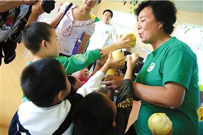孩子们让太阳村主任张淑琴先品尝梨.本报实习生王苡萱摄