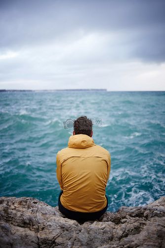 坐在石头上看海的男人