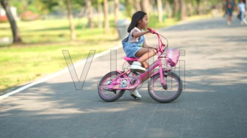 小女孩在花园里骑自行车
