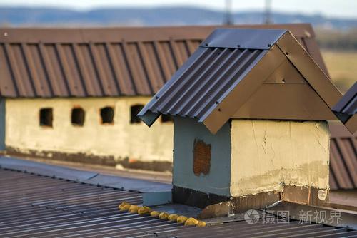 在建造的房屋屋顶上新建烟囱的特写.未完工的建筑,修理和翻新工作