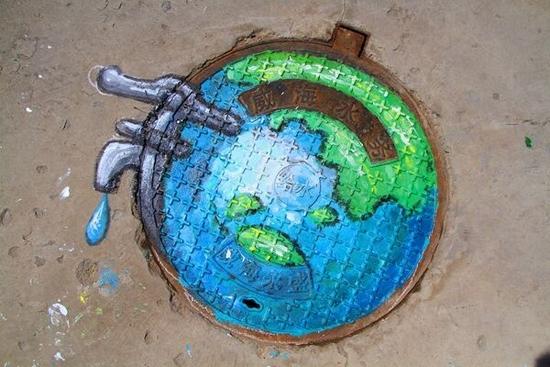 威海志愿者将绿色环保画上井盖提醒市民爱护环境