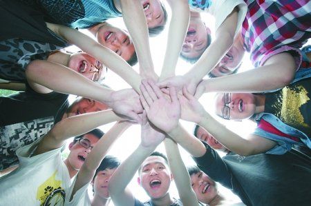 昨日,重庆一中,即将参加高考的学生们把手叠在一起相互鼓励加油.