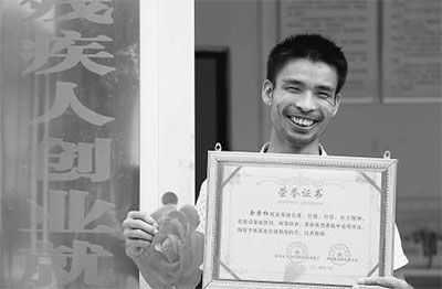 手捧着"陕西省自强模范"荣誉证书的余荣权.本报记者 方 敏摄