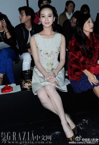 刘诗诗穿着典雅花色无袖连衣裙,拎着灯笼型宝宝,搭配金色高跟鞋,十分