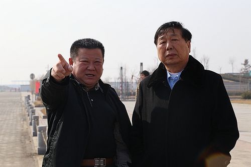 图为:常务副会长詹国海(左)向会长詹昭榜介绍鑫海化工厂区建设情况