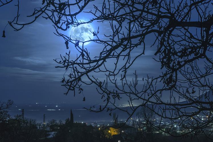 夜晚月亮对着漆黑的天空图片素材