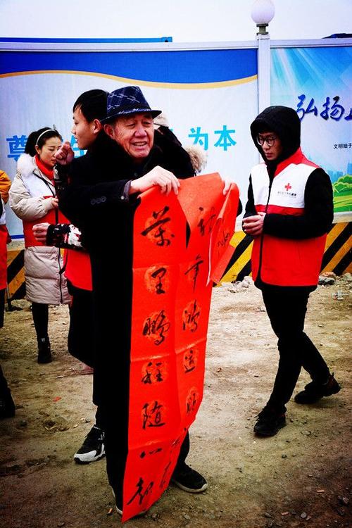 火车站游子返乡过年 红十字姜汤防寒,暖心送对联