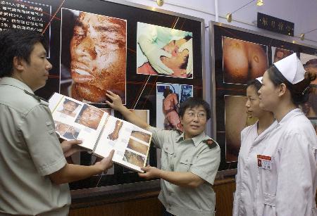 景艳(左二)在齐齐哈尔"8·4"事件纪念馆回忆对遇难者李贵珍的救治过程