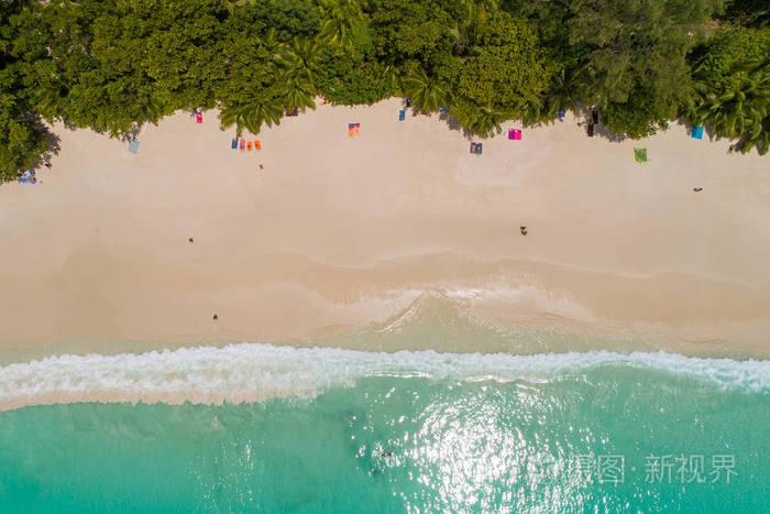 在美丽清澈的海水中游泳的游客在沙滩上鸟瞰