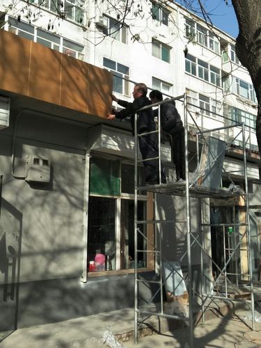 工人师傅认真仔细地安装广告牌底板