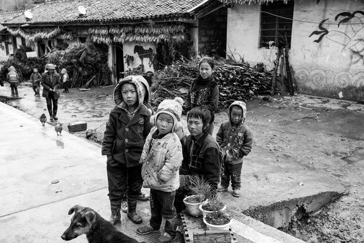 金阳县丙底乡沙洛依达村.几个孩子在靠着墙根玩耍.