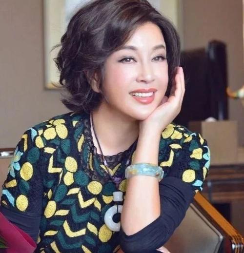 65岁刘晓庆晒美照,小腿纤细如少女,胸前玉石项链价值不菲