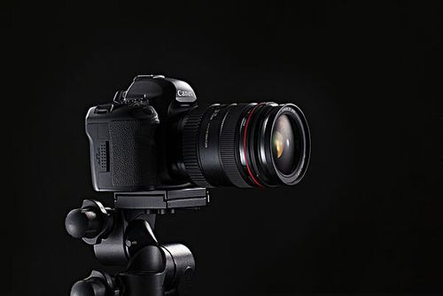 架在三脚架上的单反照相机镜头侧面_全景网