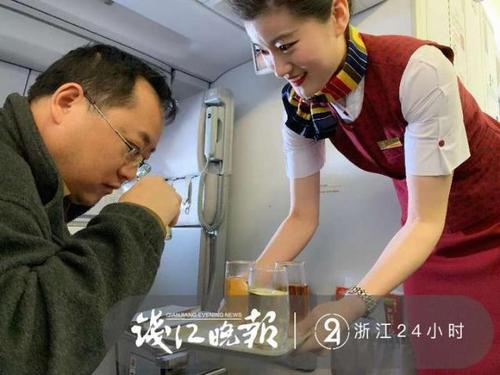 头等舱旅客贺先生双手接过乘务员奉上的龙井绿茶,凑近一闻,小吮一口