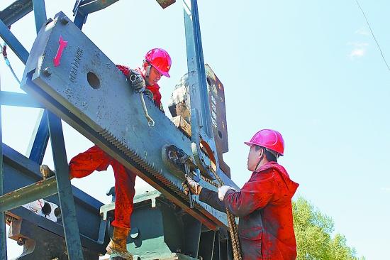 专业化抽保班组成员正在更换抽油机曲柄销子. 颜云鹏 摄