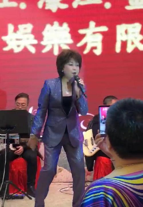 64岁歌后朱咪咪现身商演,被助理围成一圈,舞台上又蹦又跳