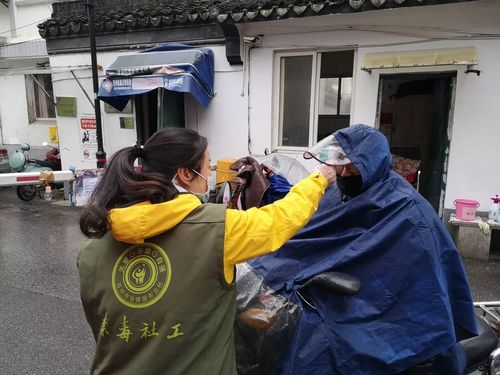 江苏省苏州市自强服务总社禁毒社工为社区居民测量体温.