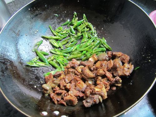 烧油倒进羊肉炒匀, 调点生抽,盐炒匀, 放井辣椒丝,在辣椒上加点盐, 再
