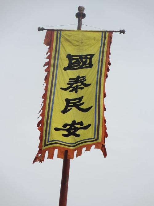 门口两个旗幡上"国泰民安,风调雨顺"