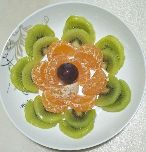 在把橘子按顺序摆放好,在放了一颗葡萄进行点缀,这样,一个简单的水果