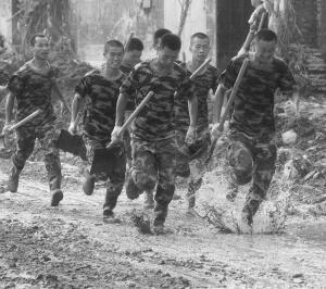 几名武警战士在泥水中快速跑过.