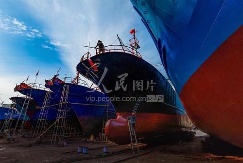 2020年7月11日,浙江宁波石浦渔港的东门船厂内,工人在给渔船涂油漆.